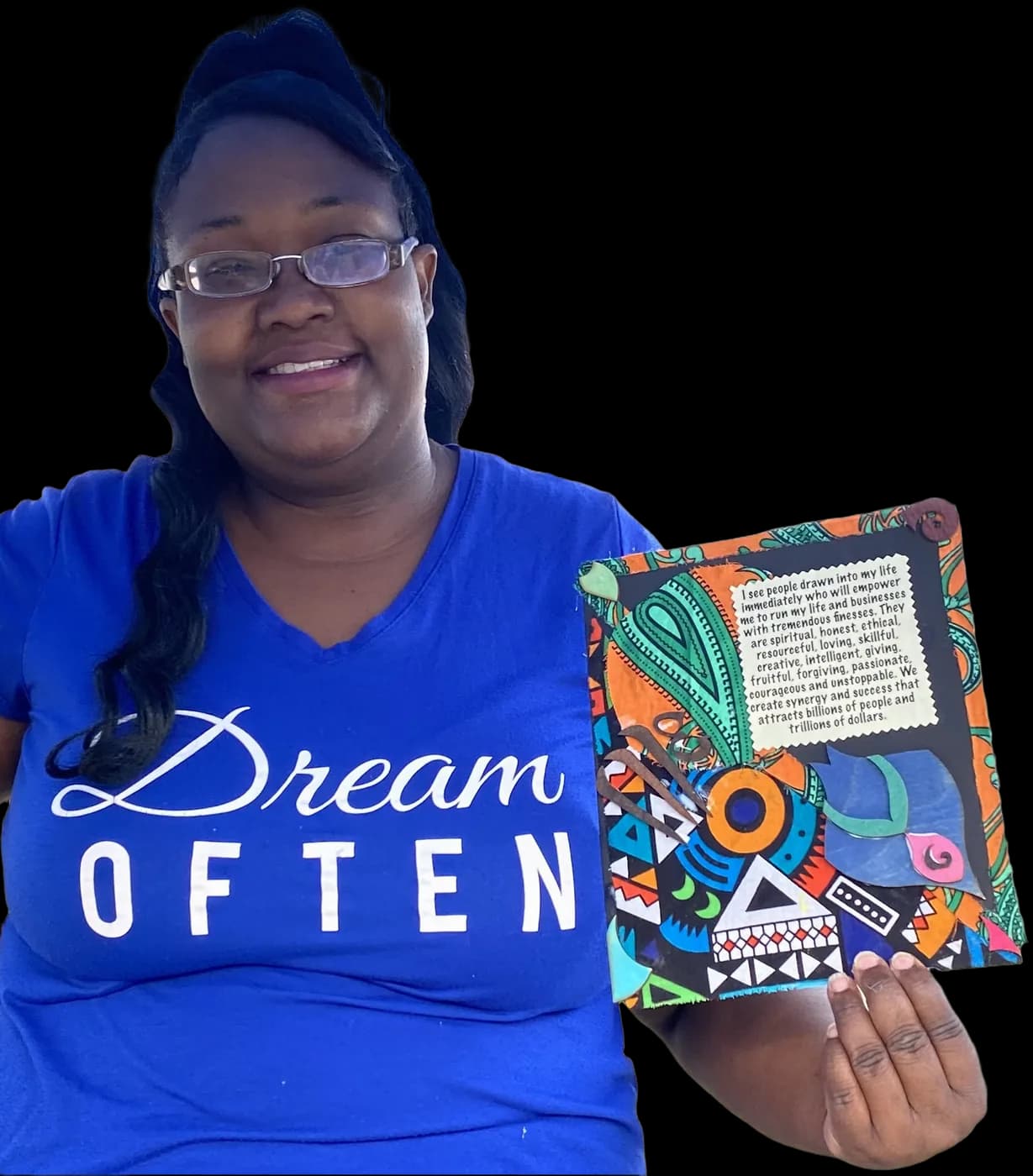 A guest in her 'Dream Often' shirt holding the collage board she made at a make & take.